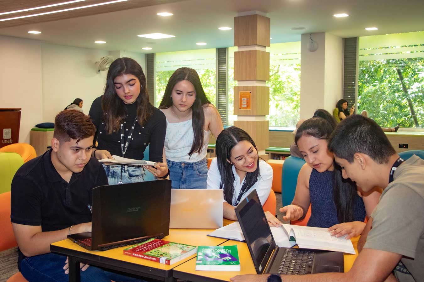 Grupo de estudiantes universitarios trabajando en una biblioteca